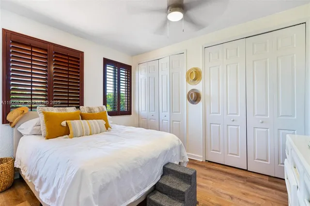 a spacious bedroom with a bed and wooden floor