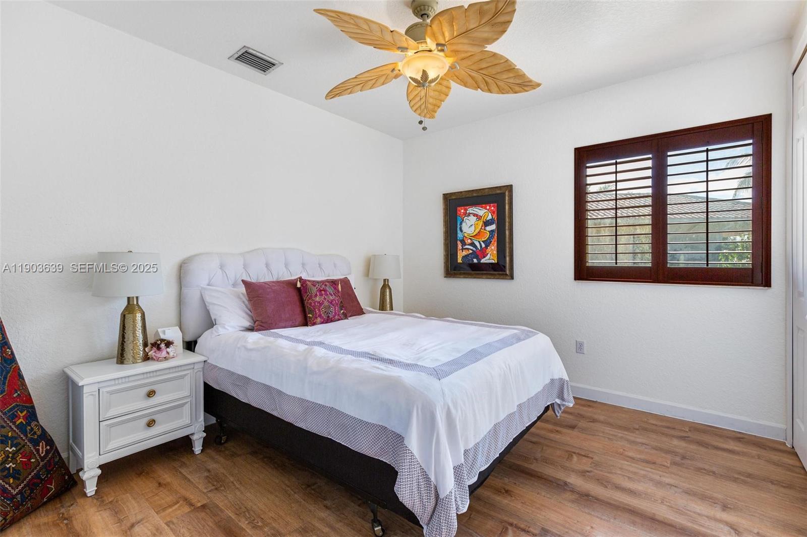 7587 Southwest 189th Street Cutler Bay, FL 33157 - Photo 32 of 66 a bedroom with a bed and a chandelier fan