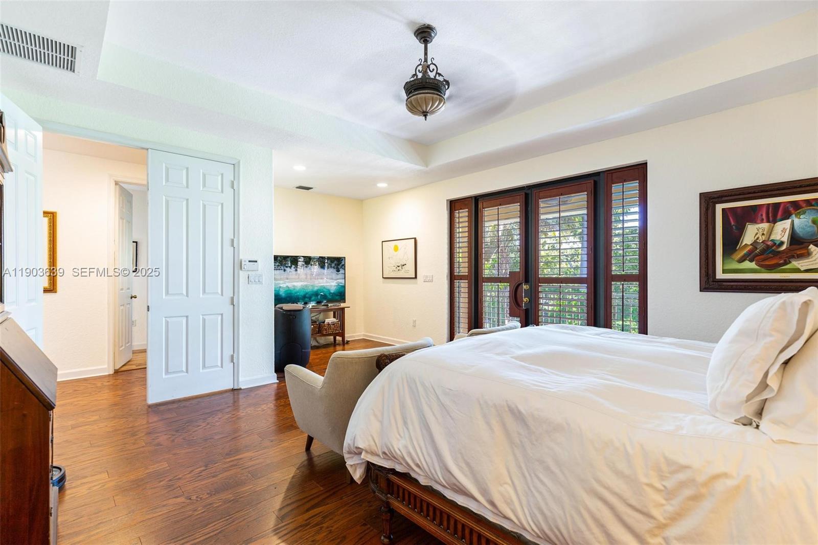 7587 Southwest 189th Street Cutler Bay, FL 33157 - Photo 39 of 66 a spacious bedroom with a large bed and a wooden floor