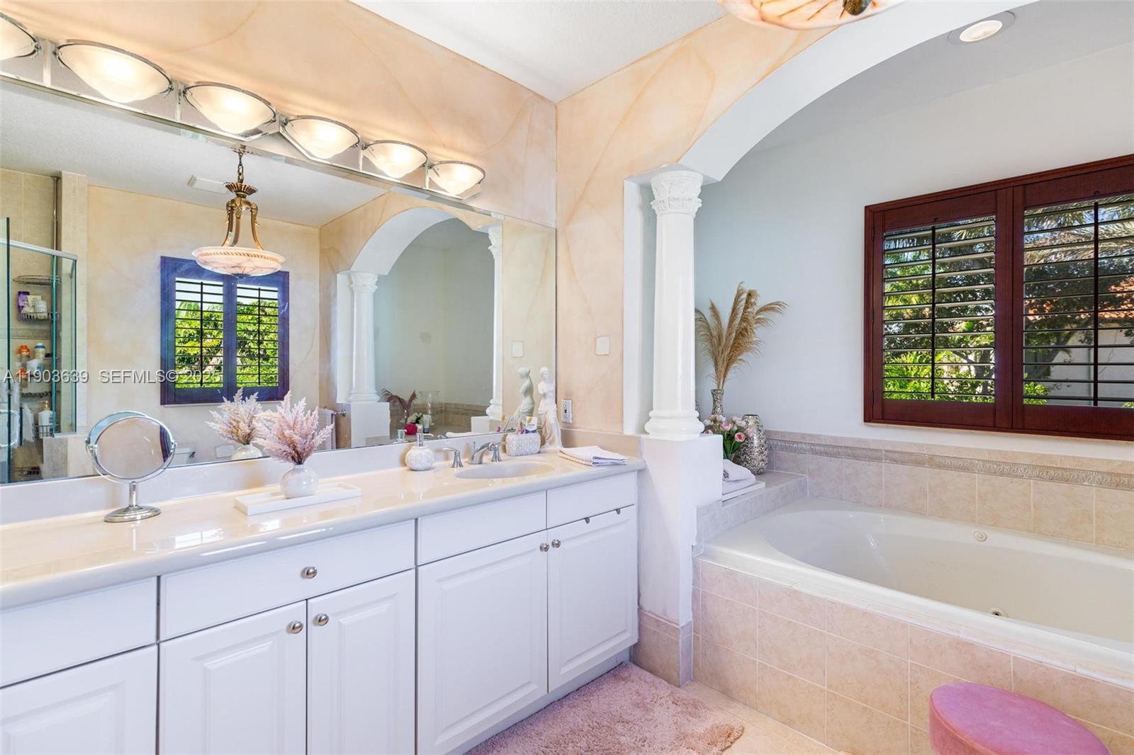 7587 Southwest 189th Street Cutler Bay, FL 33157 - Photo 41 of 66 a bathroom with a tub a sink double vanity and a large mirror