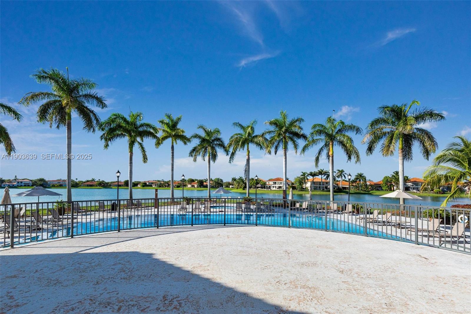 7587 Southwest 189th Street Cutler Bay, FL 33157 - Photo 60 of 66 a view of a swimming pool with a lawn chair and palm trees
