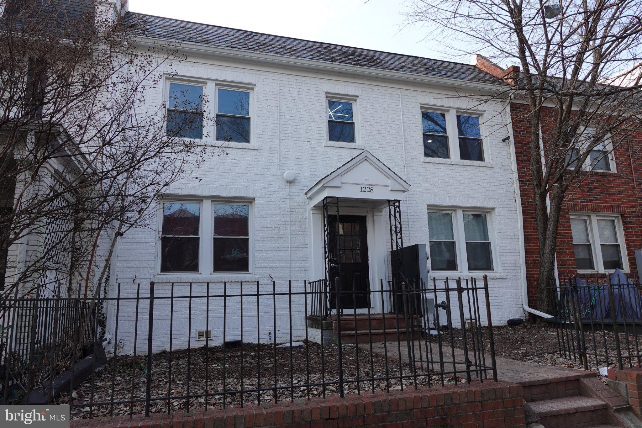 a front view of a house with iron fence