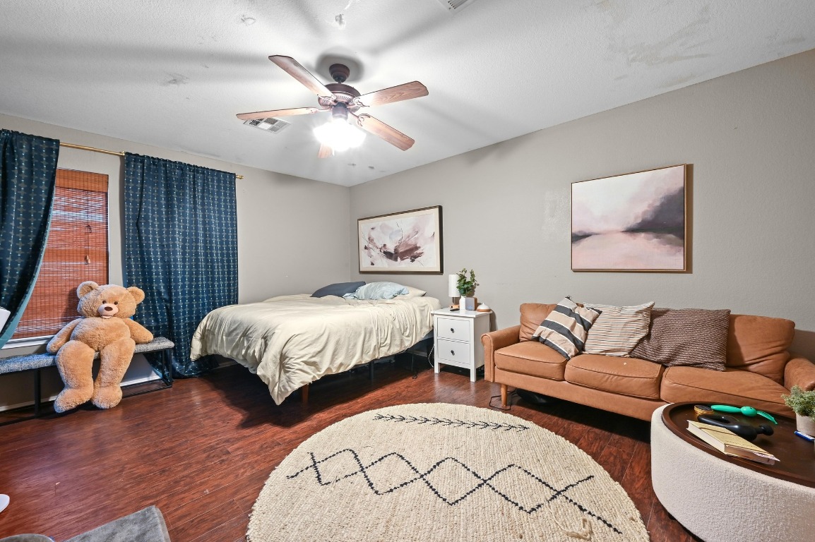 6624 Quinton Drive Austin, TX 78747 - Photo 15 of 25 a bedroom with a bed and wooden floor