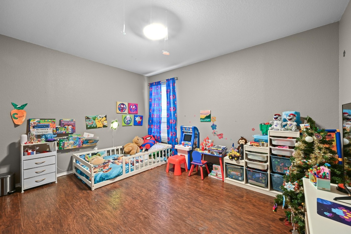 6624 Quinton Drive Austin, TX 78747 - Photo 19 of 25 a bedroom with furniture and a wooden floor