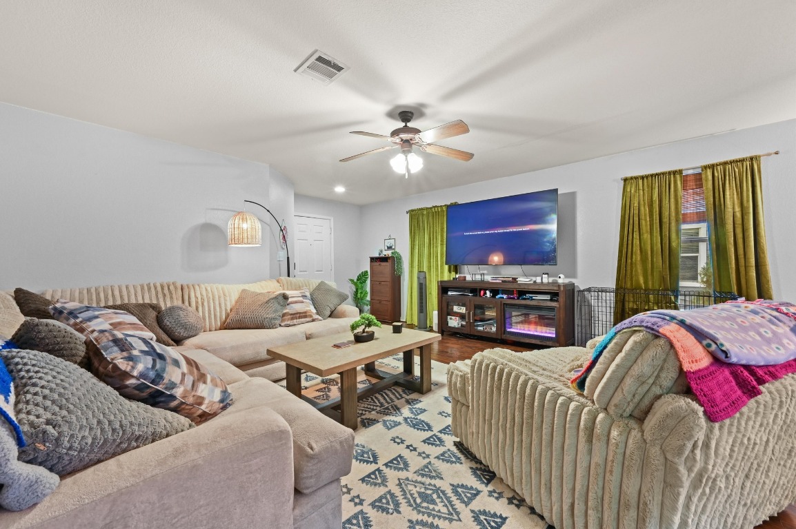 6624 Quinton Drive Austin, TX 78747 - Photo 5 of 25 a living room with furniture a fireplace and a flat screen tv