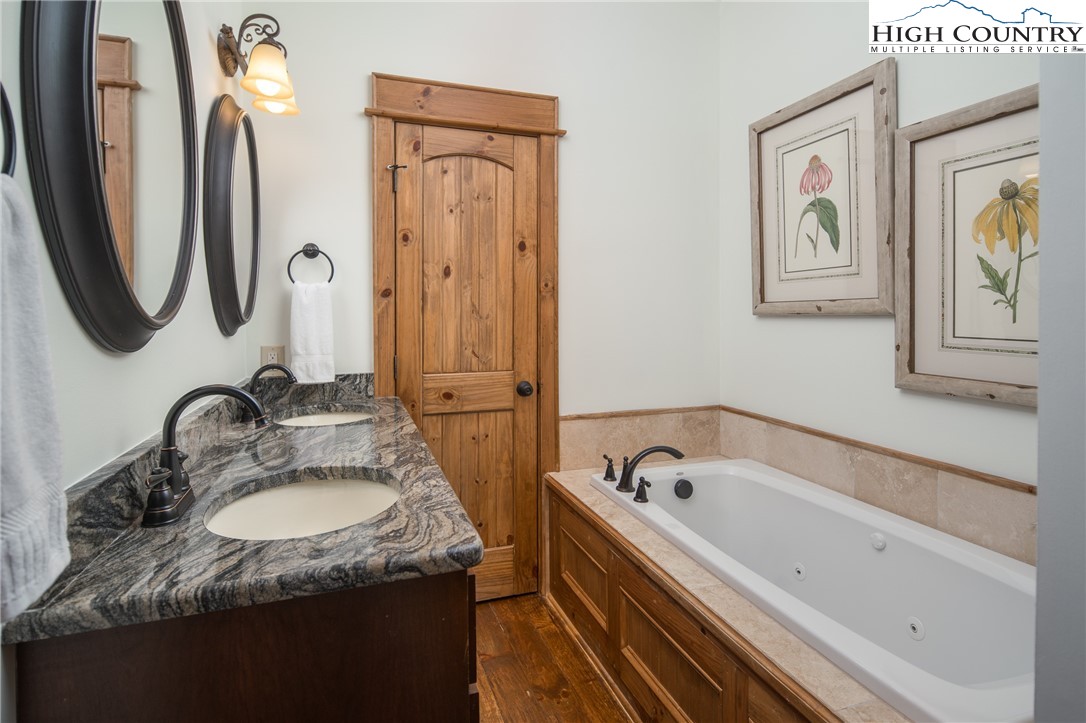 153 Stonecrop Lane Boone, NC 28607 - Photo 29 of 49 a bathroom with a granite countertop tub sink and mirror