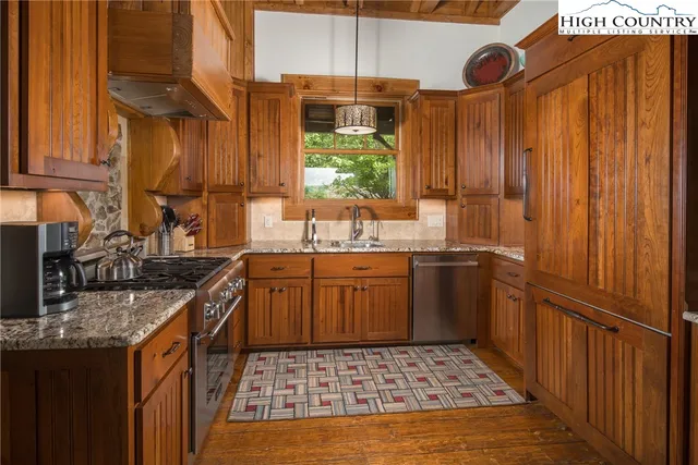a kitchen with stainless steel appliances granite countertop a stove sink and cabinets