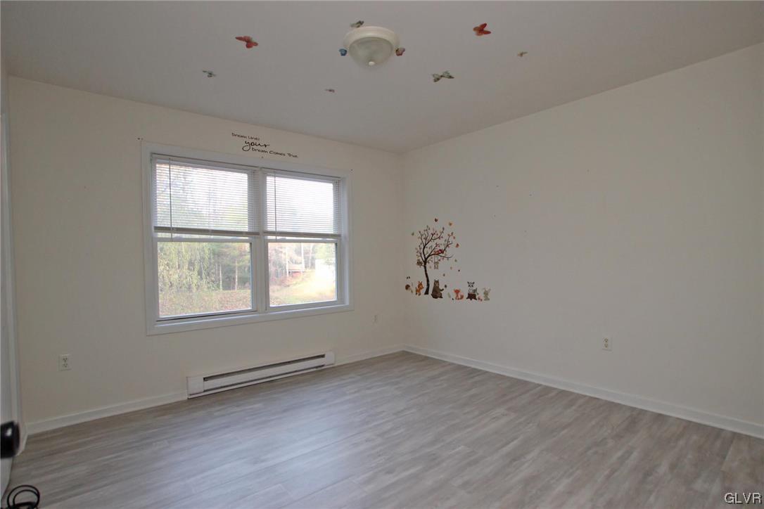 160 Spruce Drive Dingmans Ferry, PA 18328 - Photo 17 of 40 an empty room with wooden floor and windows