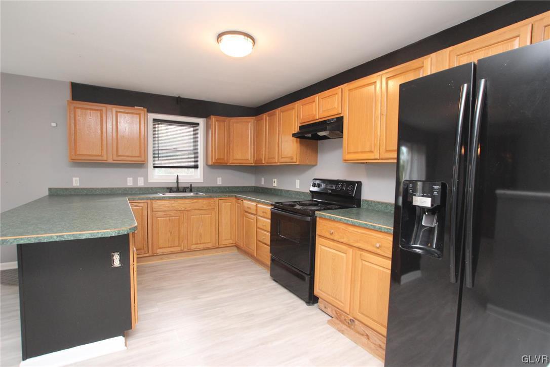 160 Spruce Drive Dingmans Ferry, PA 18328 - Photo 9 of 40 a kitchen with stainless steel appliances granite countertop a refrigerator a sink a stove and white cabinets