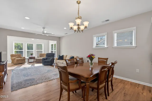 a view of a dining room with furniture a chandelier and wooden floor