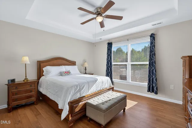 a bedroom with a bed lamp and a large window