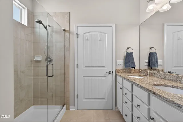 a bathroom with a granite countertop sink mirror and shower