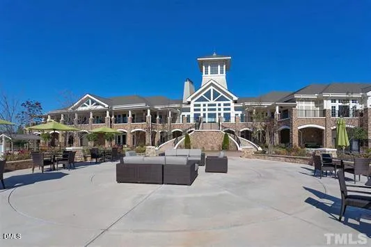 a view of a big house with couches and a fire pit