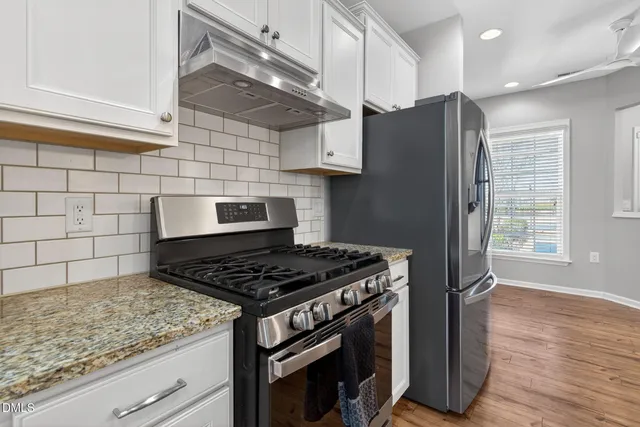 a kitchen with granite countertop a stove and a refrigerator