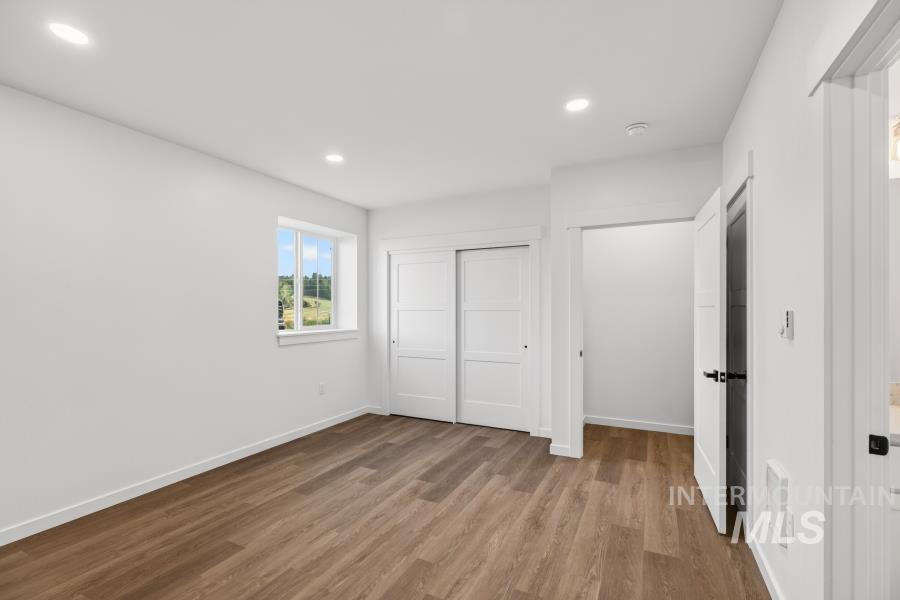 1298 Edington Moscow, ID 83843 - Photo 21 of 32 Wood-finish flooring, recessed lighting, white trim, sliding closet doors, and window with natural light