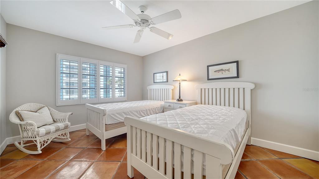 800 Benjamin Franklin Drive, Unit 406 Sarasota, FL 34236 - Photo 22 of 54 a bedroom with a bed and a table