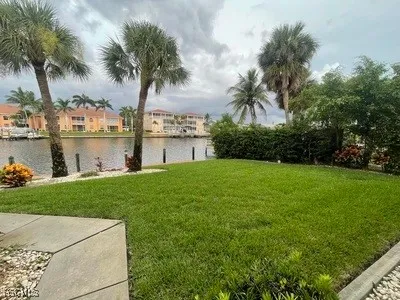a front view of a house with garden and lake view