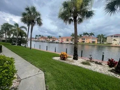 a front view of a house with garden and lake view