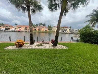 a view of a lake with a big yard and palm trees