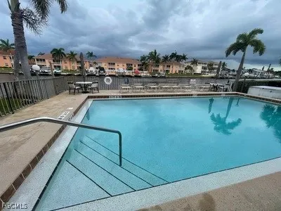 a view of a swimming pool that has lawn chairs