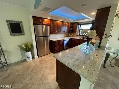 a kitchen with stainless steel appliances granite countertop a refrigerator a stove and a sink with wooden floor