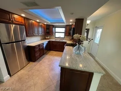 a kitchen with stainless steel appliances granite countertop a sink a stove and a refrigerator