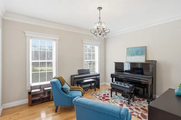 a living room with furniture a piano and a window