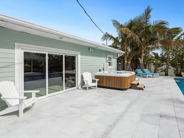 a view of a roof deck with table and chairs under an umbrella with wooden floor