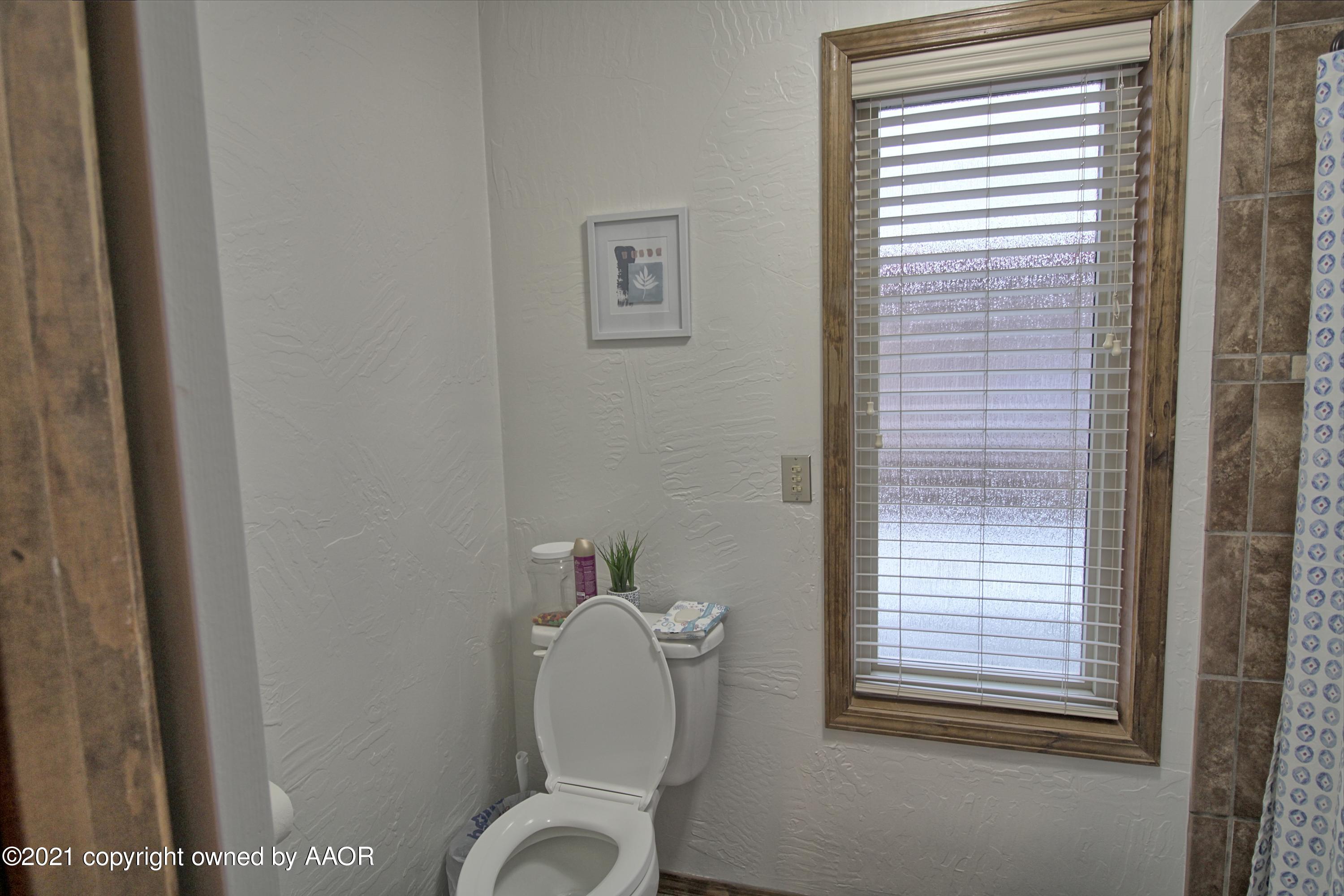 2101 Southwest 21st Avenue Perryton, TX 79070 - Photo 14 of 20 a bathroom with a toilet and a window