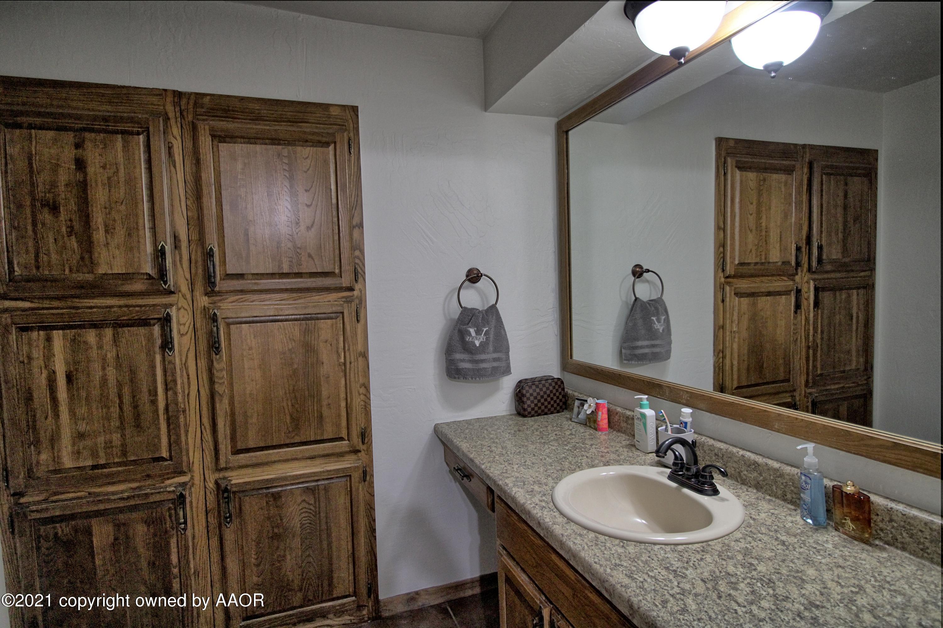 2101 Southwest 21st Avenue Perryton, TX 79070 - Photo 17 of 20 a bathroom with a sink vanity and mirror