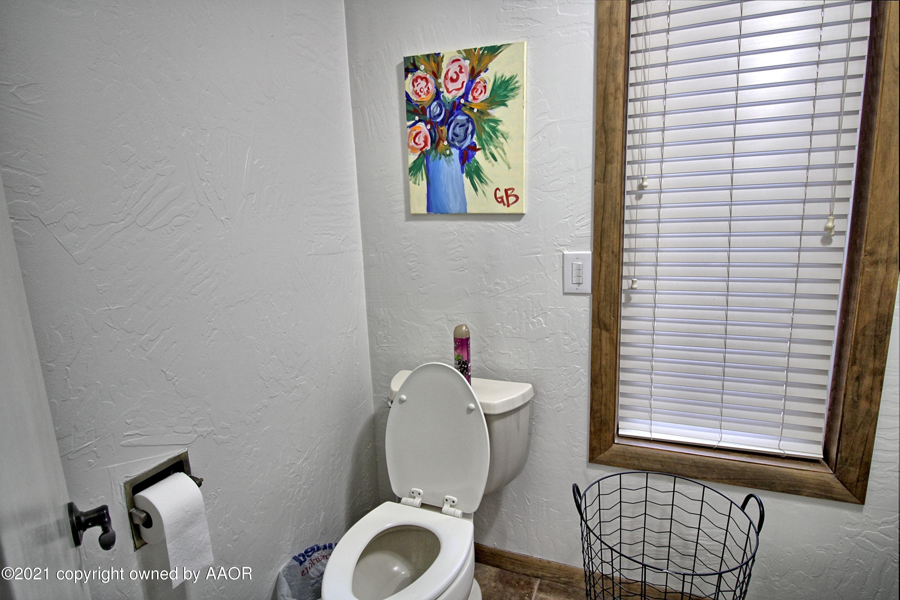 2101 Southwest 21st Avenue Perryton, TX 79070 - Photo 18 of 20 a bathroom with a toilet and a painting on the wall