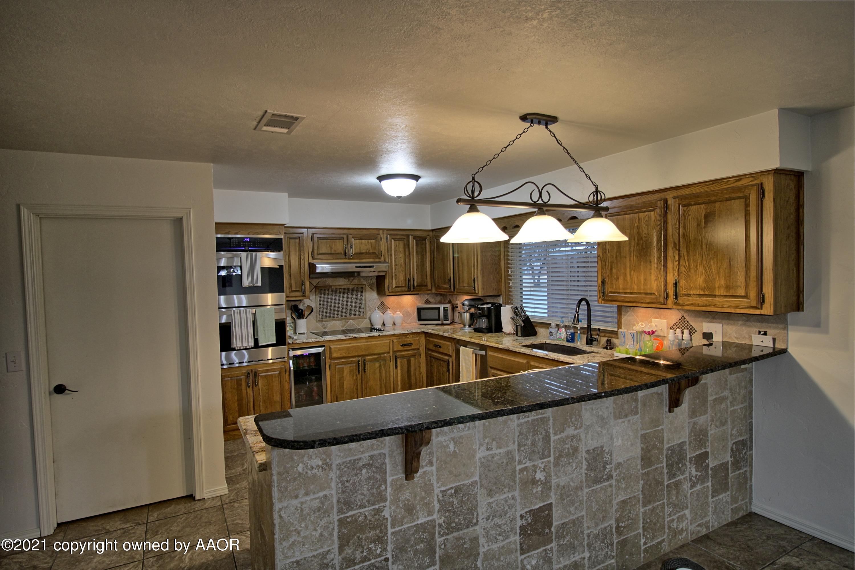 2101 Southwest 21st Avenue Perryton, TX 79070 - Photo 6 of 20 a kitchen with stainless steel appliances granite countertop a sink and a refrigerator