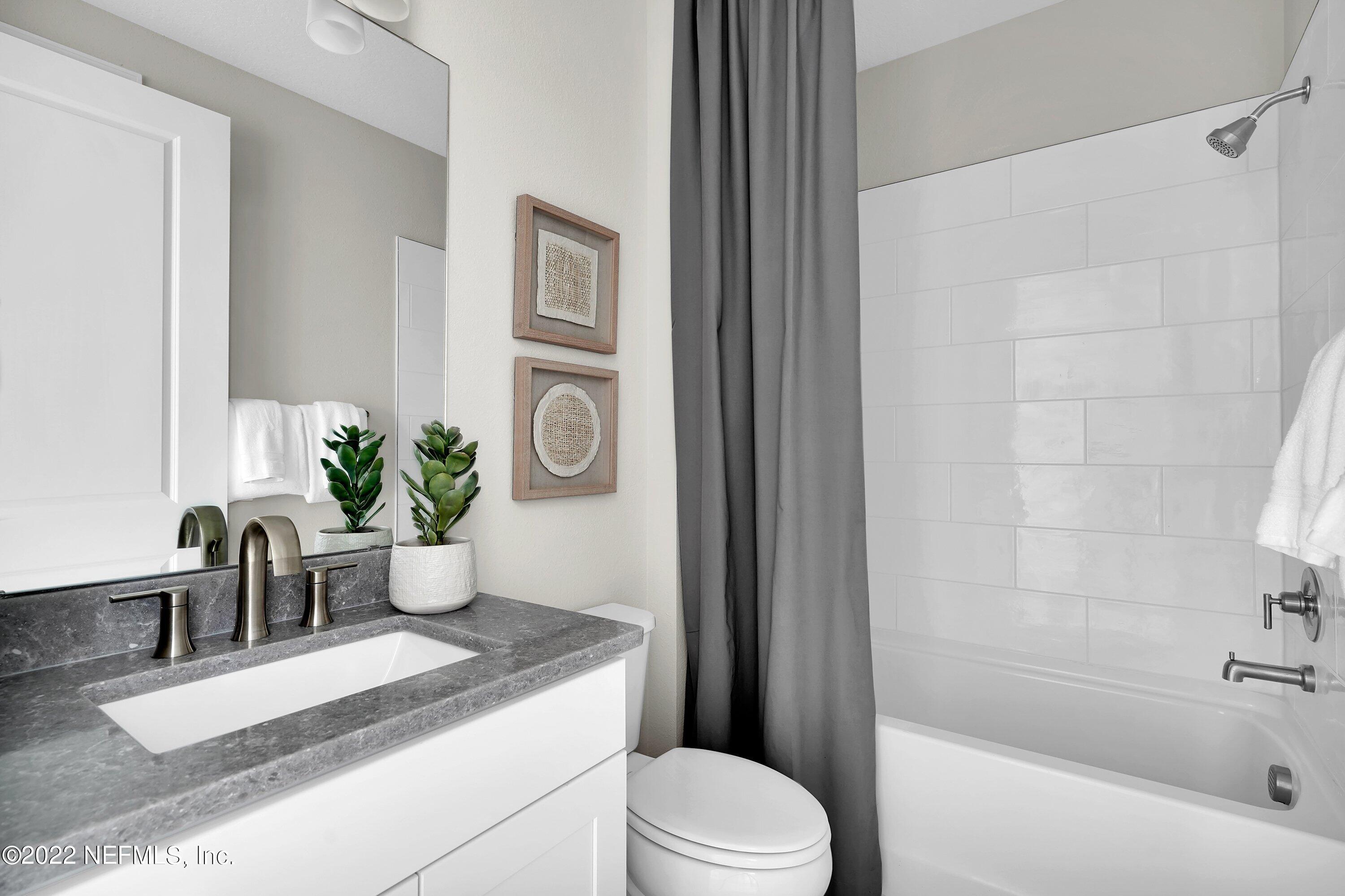 320 Del Webb Parkway Yulee, FL 32097 - Photo 15 of 16 a bath room with a toilet a sink and a bathtub