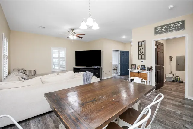 a living room with furniture a flat screen tv and kitchen view