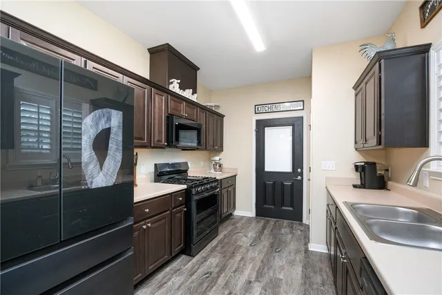 a kitchen with stainless steel appliances granite countertop a sink a stove top oven and refrigerator