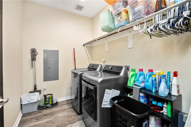 a view of a hallway with wooden floor and a bathroom