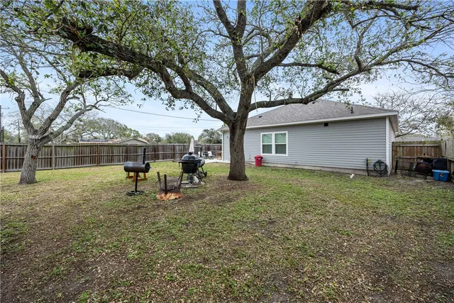 a view of a house with backyard and a tree