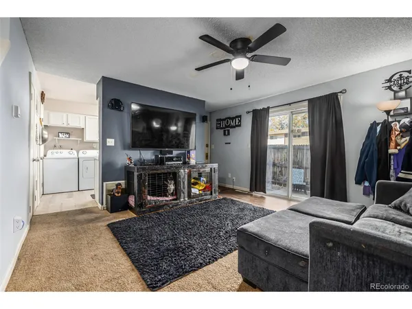a living room with stainless steel appliances kitchen island granite countertop a refrigerator stove and oven