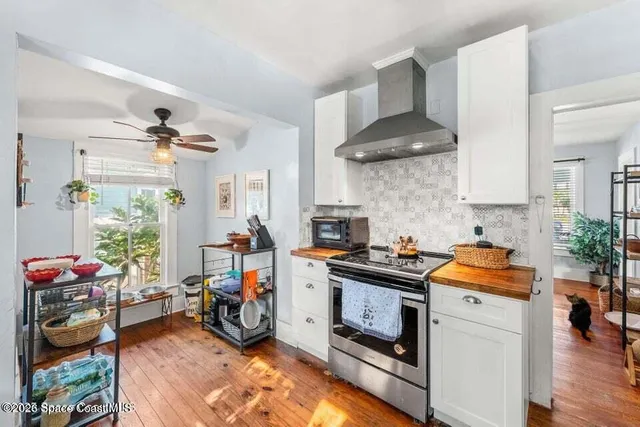 a kitchen with stainless steel appliances a stove a sink a refrigerator and wooden floor