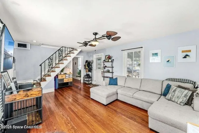 a living room with furniture and wooden floor