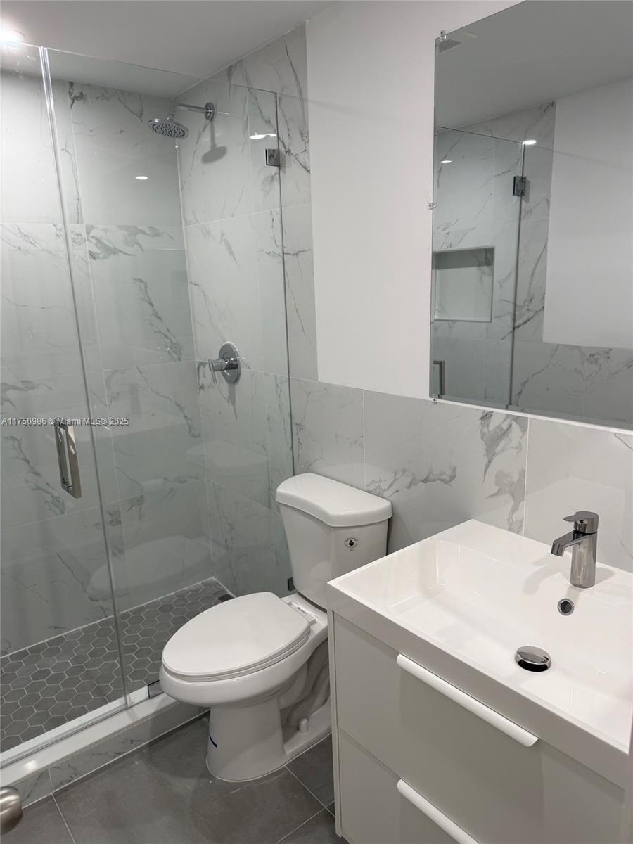 926 Michigan Avenue, Unit 12 Miami Beach, FL 33139 - Photo 8 of 14 a bathroom with a toilet sink and shower
