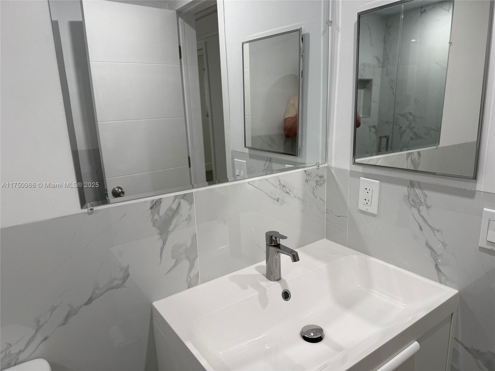 926 Michigan Avenue, Unit 12 Miami Beach, FL 33139 - Photo 9 of 14 a bathroom with a sink and a mirror