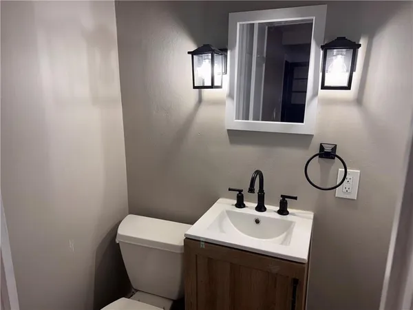 a bathroom with a toilet sink and mirror