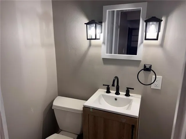 a bathroom with a toilet sink and mirror