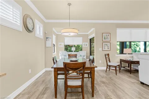 a dining room with furniture window and wooden floor