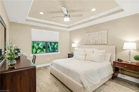 a bedroom with a bed potted plant on the dresser and a window