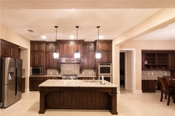 a view of kitchen with kitchen island a sink stainless steel appliances and cabinets