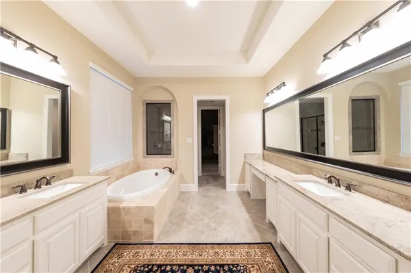 a bathroom with a sink double vanity granite and a large mirror