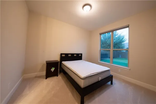 a bed sitting in a bedroom next to a window