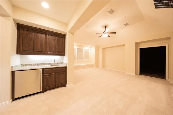 a large white kitchen with granite countertop a stove a sink and a refrigerator